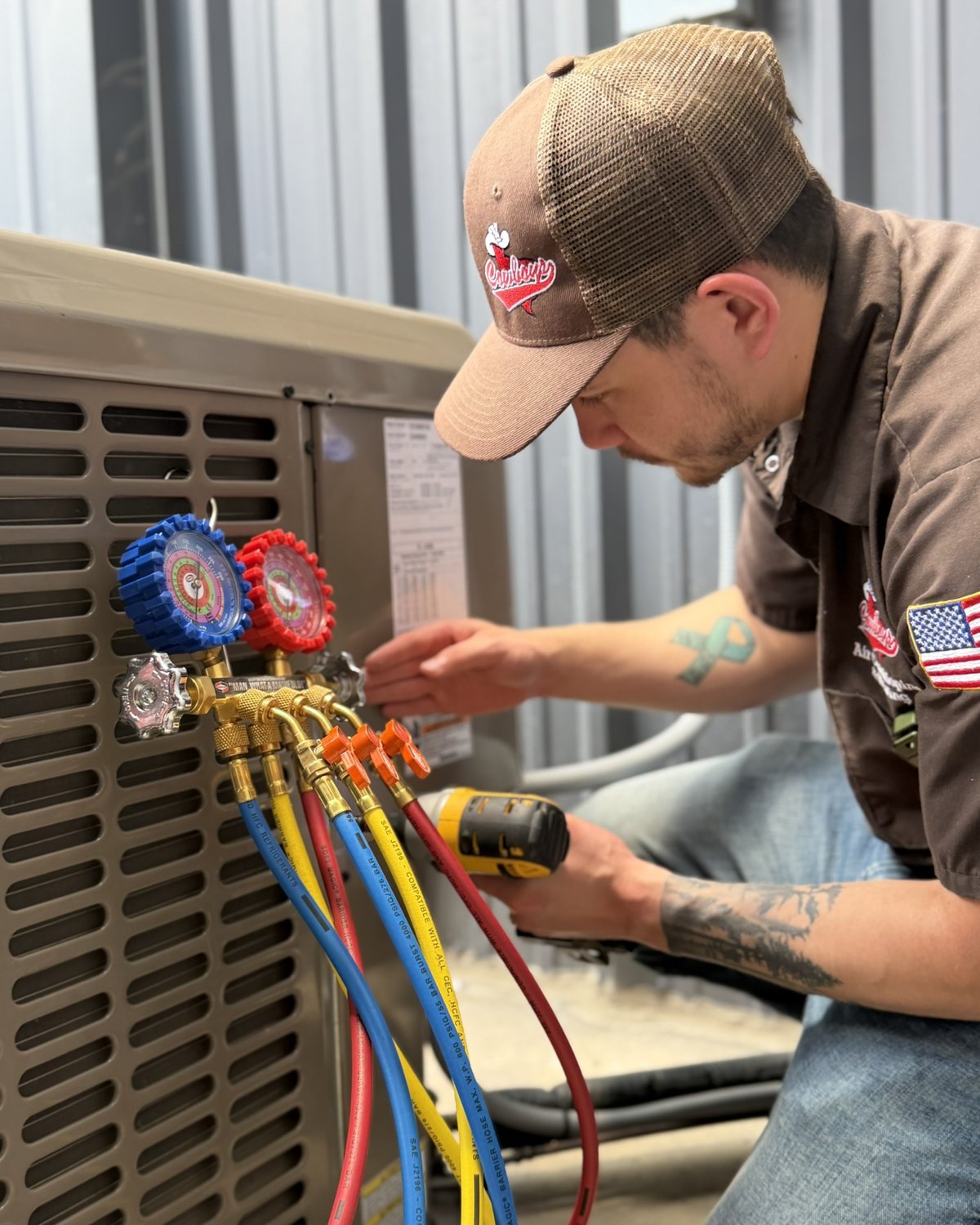 A Cowboy's tech hooking gauges to an outdoor condenser