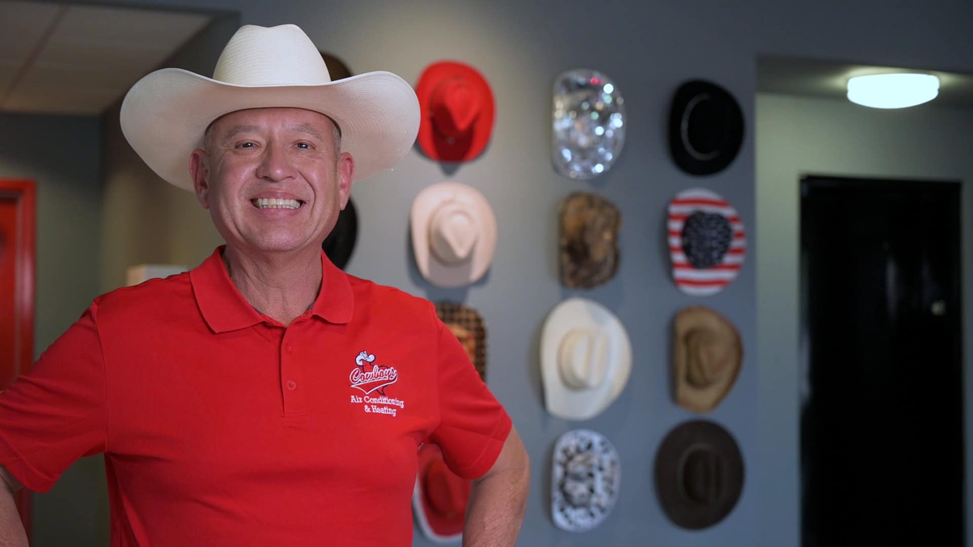 Al, founder of Cowboy's Air Conditioning & Heating, smiling in a white hat and red Cowboy's shirt at the Blanco Road shop