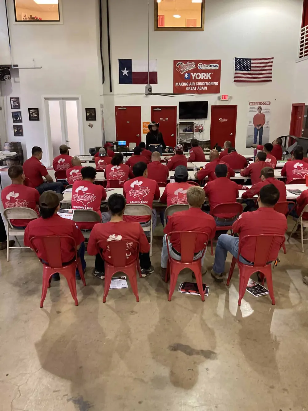 Technicians in red Cowboy's shirts in a classroom training session at the shop